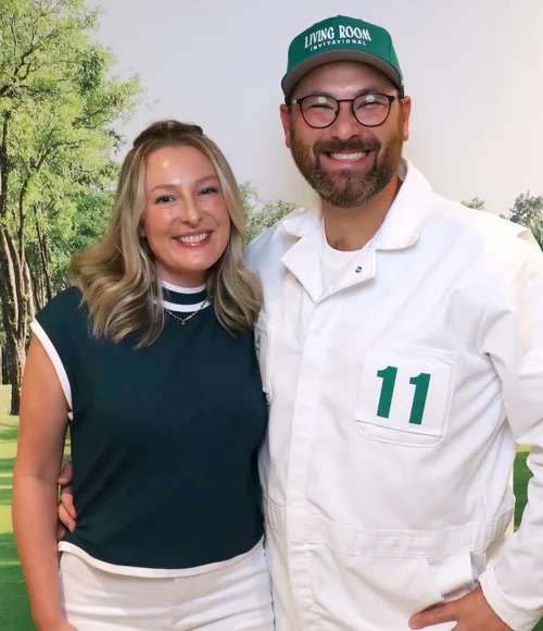 Two players in Living Room Invitational gear at the 2025 photo backdrop